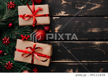 Christmass flatlay gift boxes,red christmas tree toys and spruce brance on wooden background. Christmass flatlay gift boxes,red christmas tree toys and spruce brance on wooden background. 99112836