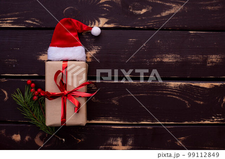 Christmass flatlay gift box,Santa hat and christmas spruce branch on wooden background. Christmass flatlay gift box,Santa hat and christmas spruce branch on wooden background. 99112849