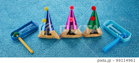 Purim celebration concept. Jewish carnival background. hamantaschen or hamans ears cookies and noisemaker 99114961