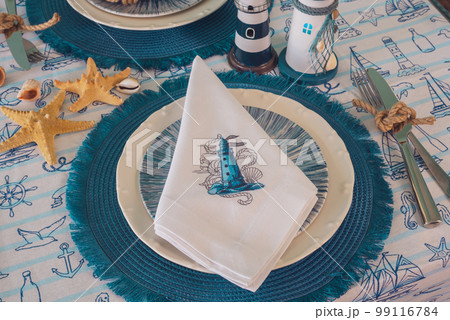 Napkin with an embroidered beacon on a plate. Blue color, marine style, table setting 99116784