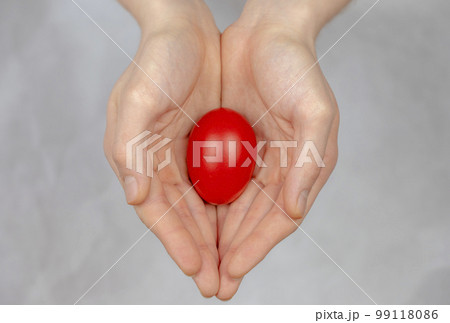 Red Easter egg lying in his palm, a religious symbol. Red Easter egg lying in his palm, a religious symbol. 99118086