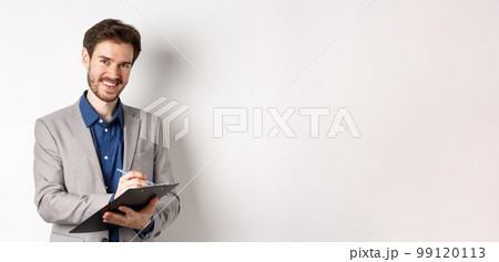 Smiling male manager in suit writing on clipboard, taking notes at office meeting, standing on white background Smiling male manager in suit writing on clipboard, taking notes at office meeting, standing on white background 99120113