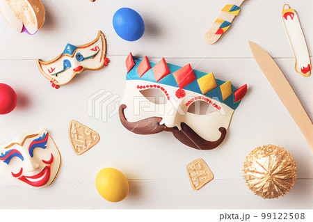 3D illustration of Purim celebration concept with Jewish carnival holiday over wooden white background. View from the top, flat lay. 99122508