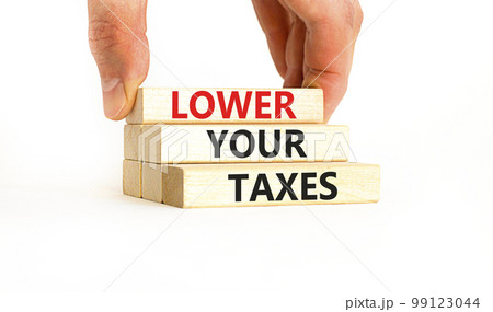 Lower your taxes symbol. Concept words Lower your taxes on wooden blocks on a beautiful white table white background. Businessman hand. Business tax lower your taxes concept. Copy space. 99123044