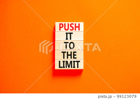 Push it to the limit symbol. Concept words Push it to the limit on wooden blocks. Beautiful orange table orange background. Business push it to the limit concept. Copy space. 99123079
