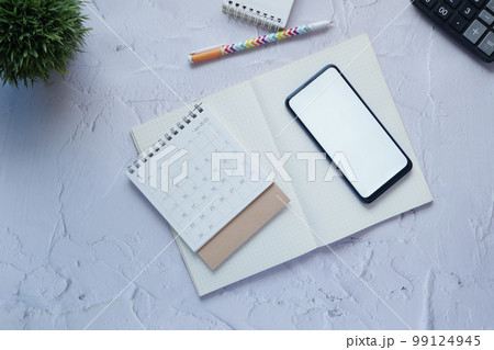 top view of calendar and smart phone with white screen on table, 99124945