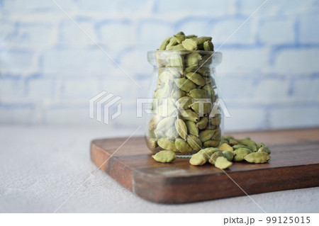 Cardamom spoon in a jar on table  99125015