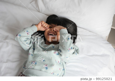 a upset child girl crying on bed  99125021
