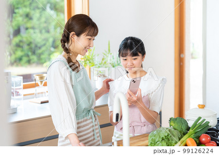 キッチンでスマホを操作する親子 99126224