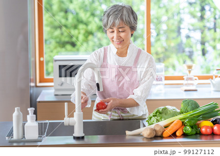 キッチンに立つ笑顔のシニア女性 キッチンに立つ笑顔のシニア女性 99127112