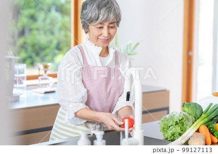 キッチンに立つ笑顔のシニア女性 キッチンに立つ笑顔のシニア女性 99127113