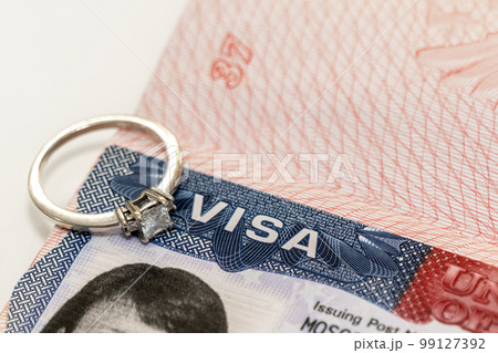 Close-up of a diamond ring on a US visa as an idea for a marriage move 99127392