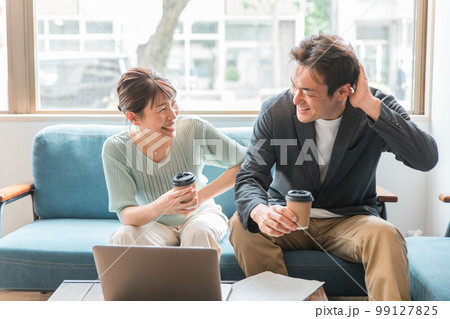 オフィス・家・カフェでコーヒーを飲みながら仕事する男女(笑顔・楽しい・照れる・褒める) オフィス・家・カフェでコーヒーを飲みながら仕事する男女(笑顔・楽しい・照れる・褒める) 99127825