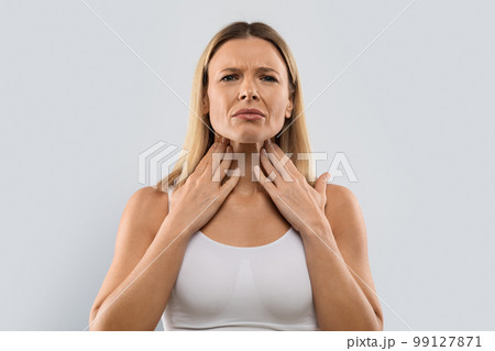 Unhappy blonde woman touching her neck, checking adenoids Unhappy blonde woman touching her neck, checking adenoids 99127871