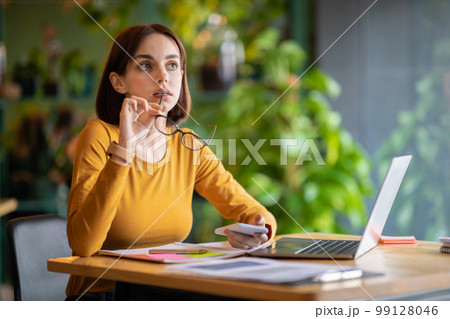 Pensive woman independent contractor working at cafe, using laptop, phone 99128046