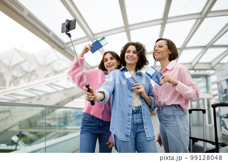 Portrait Of Three Happy Women Taking Photo Together At Airport 99128048