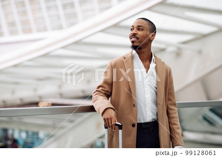 Handsome Black Man Wearing Stylish Coat Standing At Modern Airport 99128061
