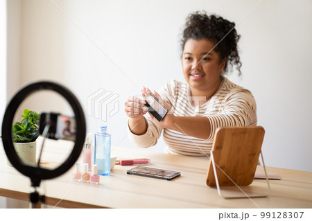 Friendly pretty chubby young lady makeup artist recording video 99128307