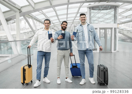 Three Travelers Men Holding Tickets Standing With Suitcases In Airport 99128336