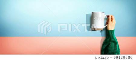 Female hand holding a mug overhead view 99129586