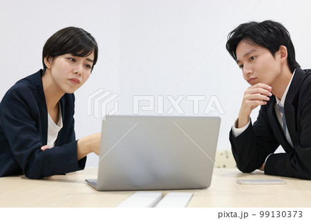 _悪化している状況をPCで見て不安な表情のビジネスパーソン男女2 _悪化している状況をPCで見て不安な表情のビジネスパーソン男女2 99130373