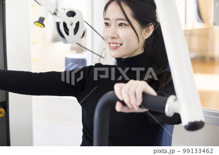 フィットネスジムで普段着でトレーニングをする若い女性　コンビニジムイメージ 99133462