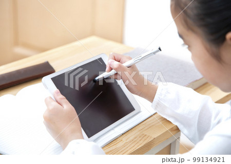 タブレットを使い勉強する小学生の女の子 タブレットを使い勉強する小学生の女の子 99134921