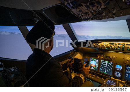 A man is studying to be a pilot in an aircraft simulator.  99136547