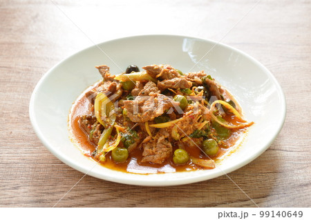 spicy fried barking deer meat with curry and eggplant on plate 99140649