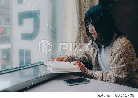 喫茶店で読書をする女性の写真 99141709