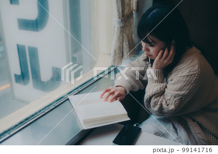 喫茶店で読書をする女性の写真 99141716