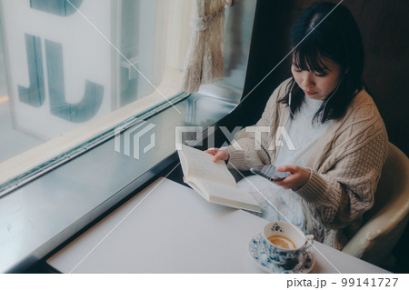 喫茶店で読書をする女性の写真 99141727
