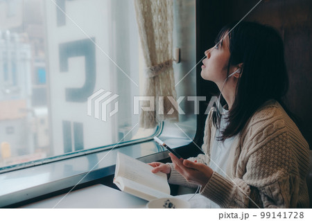 喫茶店で読書をする女性の写真 99141728