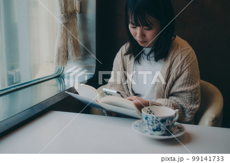 喫茶店で読書をする女性の写真 99141733
