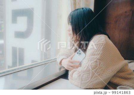 喫茶店でスマホをさわる女性の写真 99141863