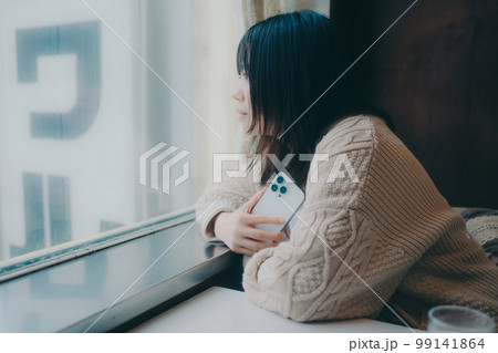 喫茶店でスマホをさわる女性の写真 喫茶店でスマホをさわる女性の写真 99141864