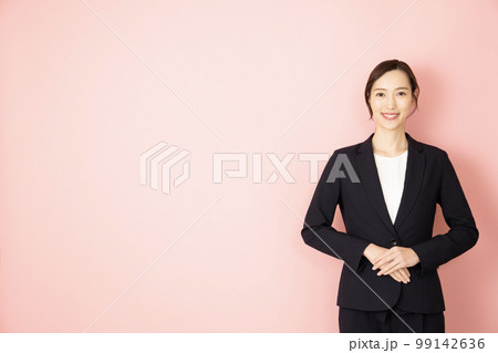 ピンクバックでネイビーのスーツを着た女性 99142636