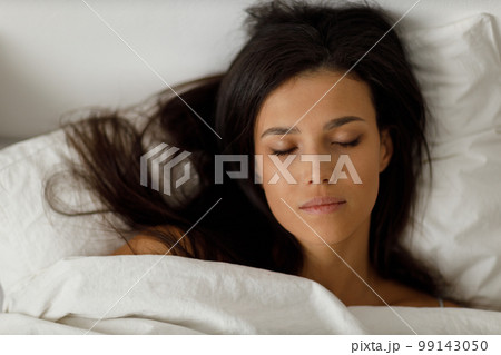 Healthy young woman dressing nightie lying on bed in bedroom. 99143050