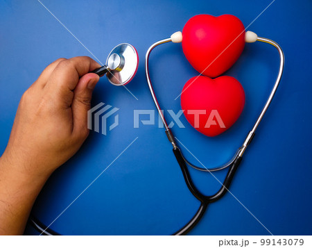Hand holding statehoscope checking red heart .Healthcare and medical concept. Hand holding statehoscope checking red heart .Healthcare and medical concept. 99143079