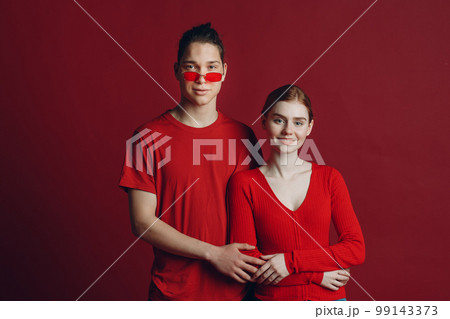 Beautiful young smiling couple hugging on red background. Valentine's day concept. Beautiful young smiling couple hugging on red background. Valentine's day concept. 99143373