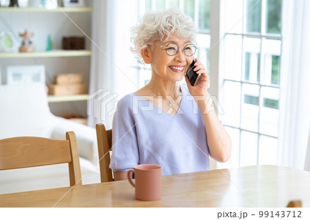 リビングで電話するシニア女性 99143712