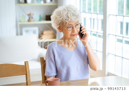 リビングで電話するシニア女性 99143713
