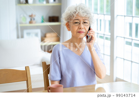 リビングで電話するシニア女性 99143714