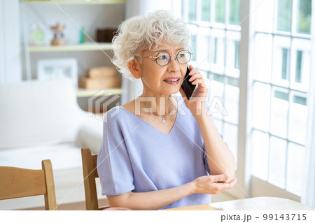 リビングで電話するシニア女性 99143715