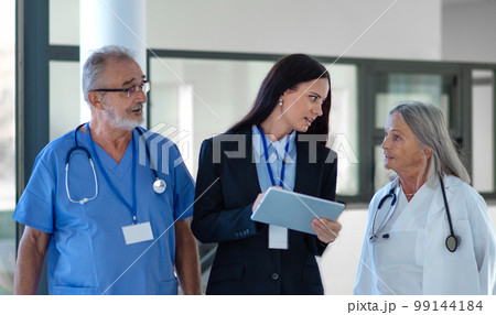 Young pharmaceutic seller explaining something to doctors in hospital. 99144184