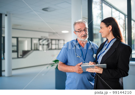 Young business woman shaking hand with elderly doctor. Young business woman shaking hand with elderly doctor. 99144210