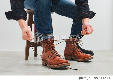 ブーツを結ぶジーンズの男1 99144214