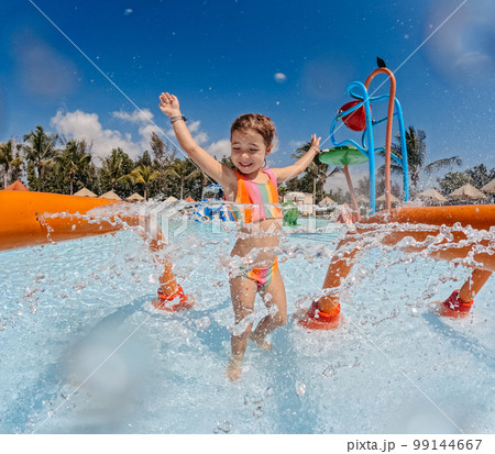 Little girl enjoying water amusement park at family vacation. 99144667