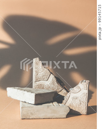 Product showcase. Stone podium. Nature stage. Cracked concrete rock pieces pile scene palm leaf shadow on beige copy space advertising background. Product showcase. Stone podium. Nature stage. Cracked concrete rock pieces pile scene palm leaf shadow on beige copy space advertising background. 99145715