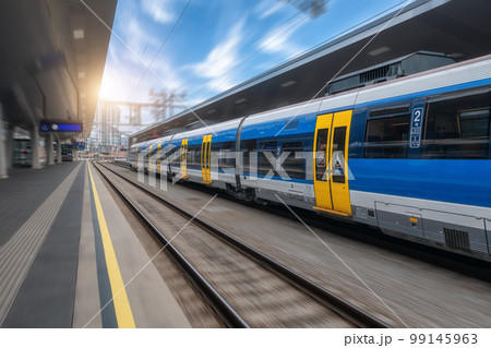 Blue high speed train in motion on the railway station at sunset 99145963